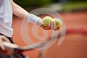 Tennis balls in playerÃ¢â¬â¢s hand photo